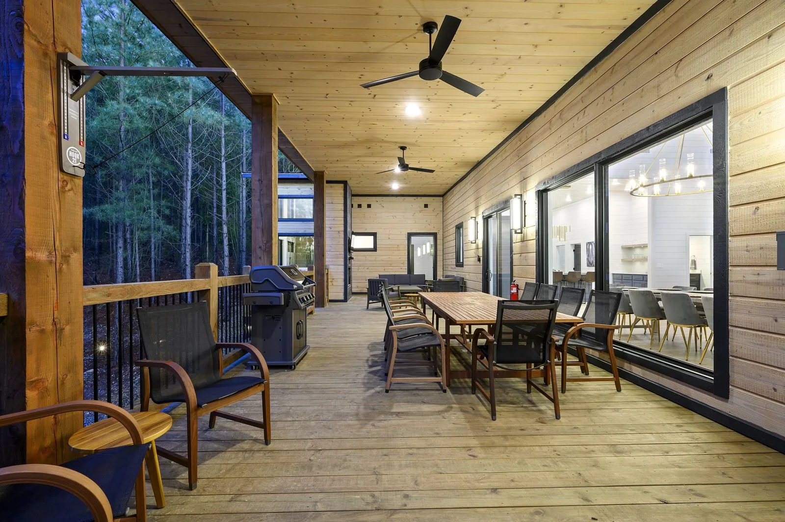 Hot tub on lower covered deck at The Arcadia surrounded by pine trees at twilight
