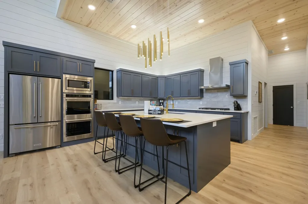 Gas cooktop close-up with marble backsplash and stainless hood in The Arcadia kitchen