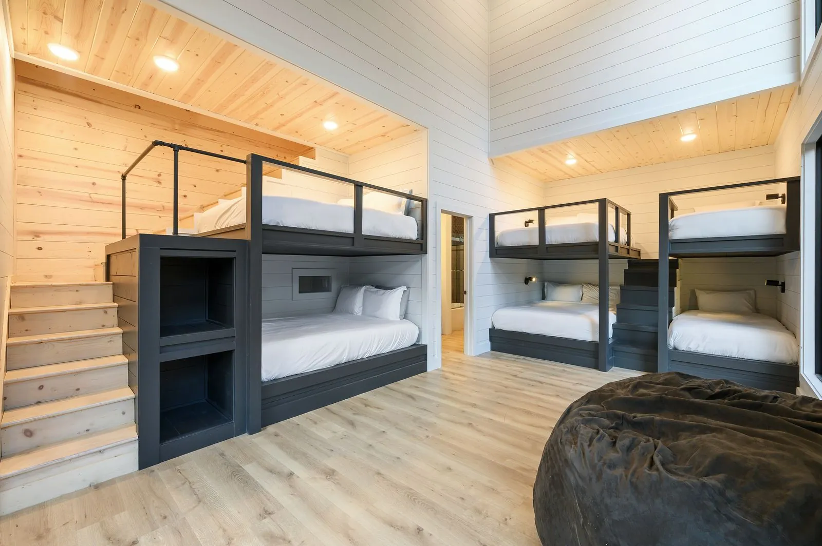 Built-in bunk beds close-up at The Arcadia with individual wall-mounted lights and white bedding