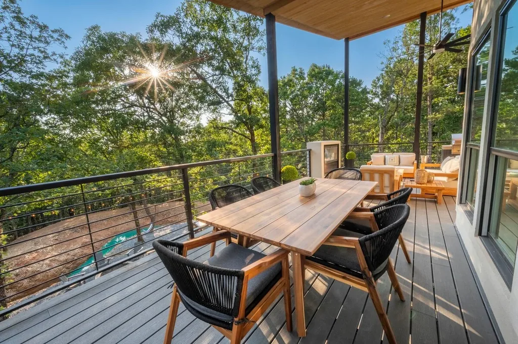 Outdoor dining and lounge overlooking the trees at The Aroha
