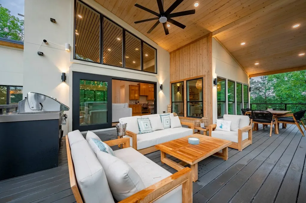 Covered outdoor living room, dining table, and grill at The Aroha