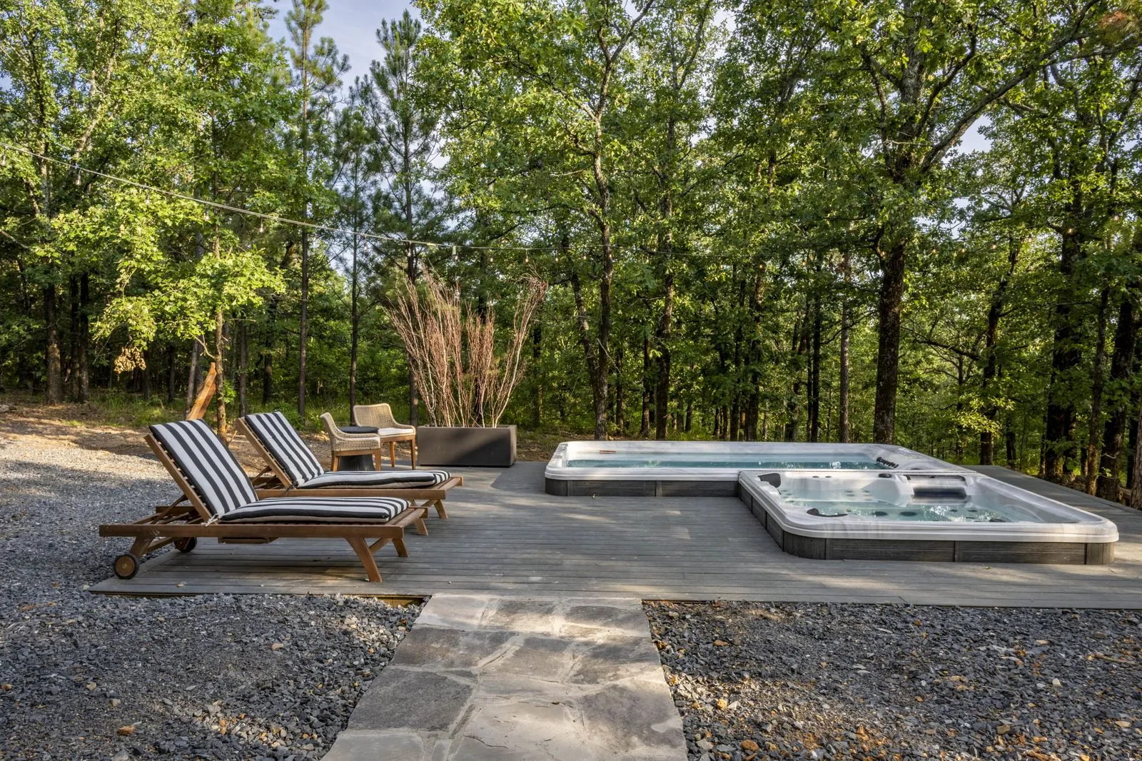 Sun loungers and hot tub on the deck at The Aroha among the trees