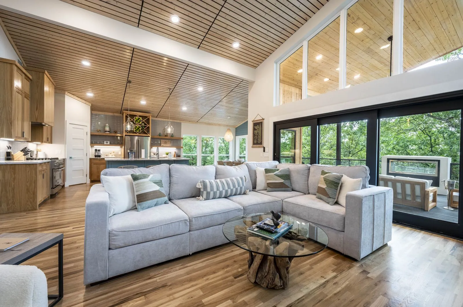 Vaulted slatted wood ceiling in the great room at The Aroha with pendant lights and forest views