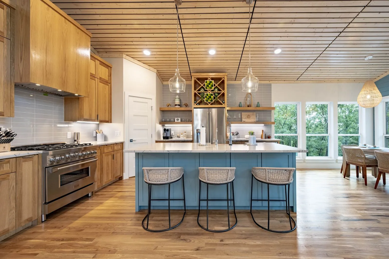 Chef&rsquo;s kitchen at The Aroha with a blue island, gas range, and bar seating