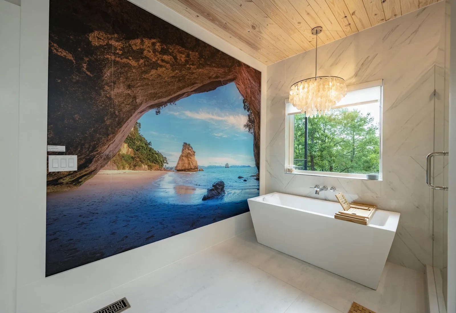 Spa bathroom at The Aroha with a freestanding tub beneath a New Zealand mural