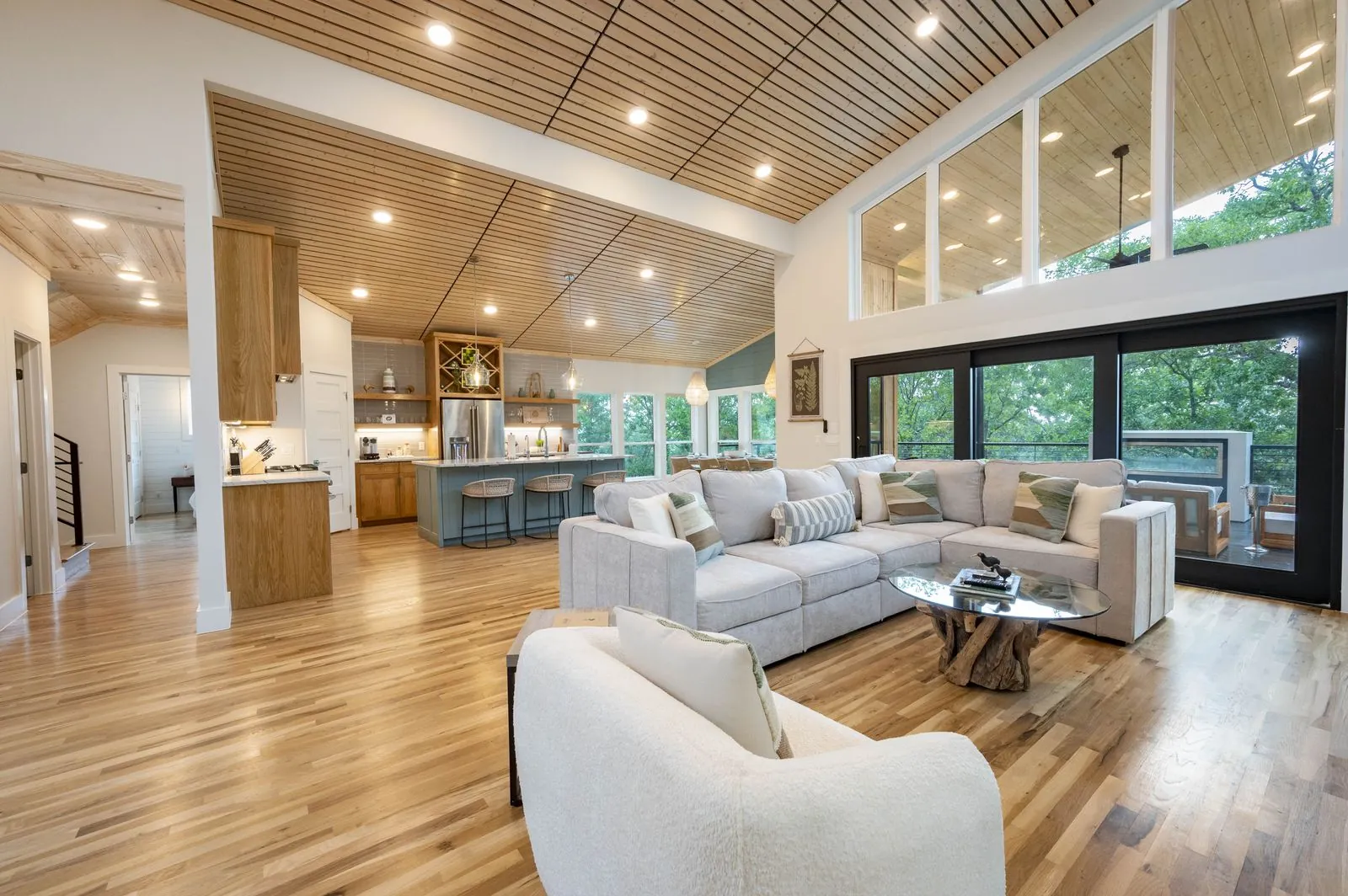 Open great room at The Aroha with a slatted wood ceiling and white sofas
