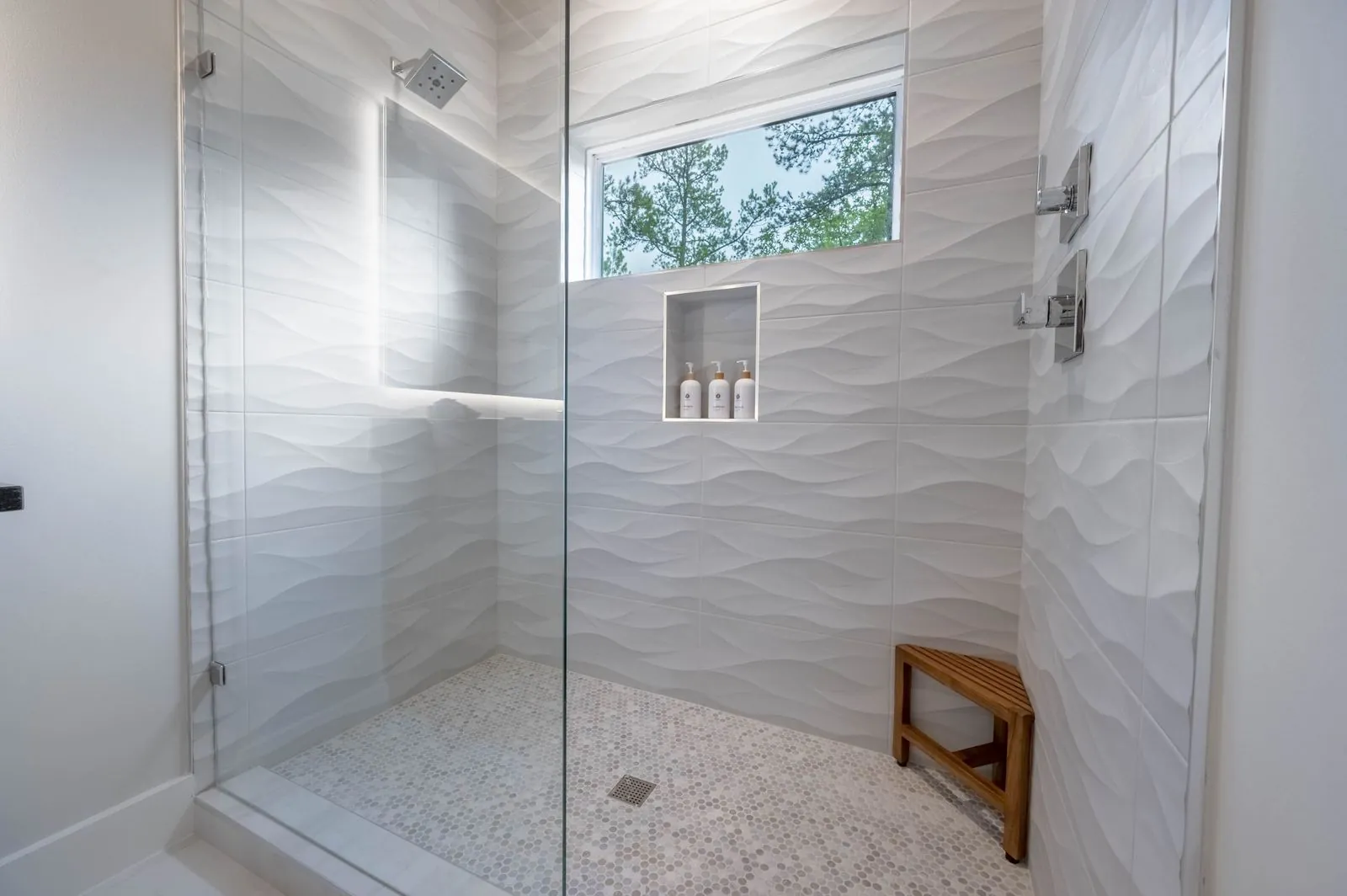 Primary bathroom at The Aroha with freestanding soaking tub, wood ceiling, and double vanity
