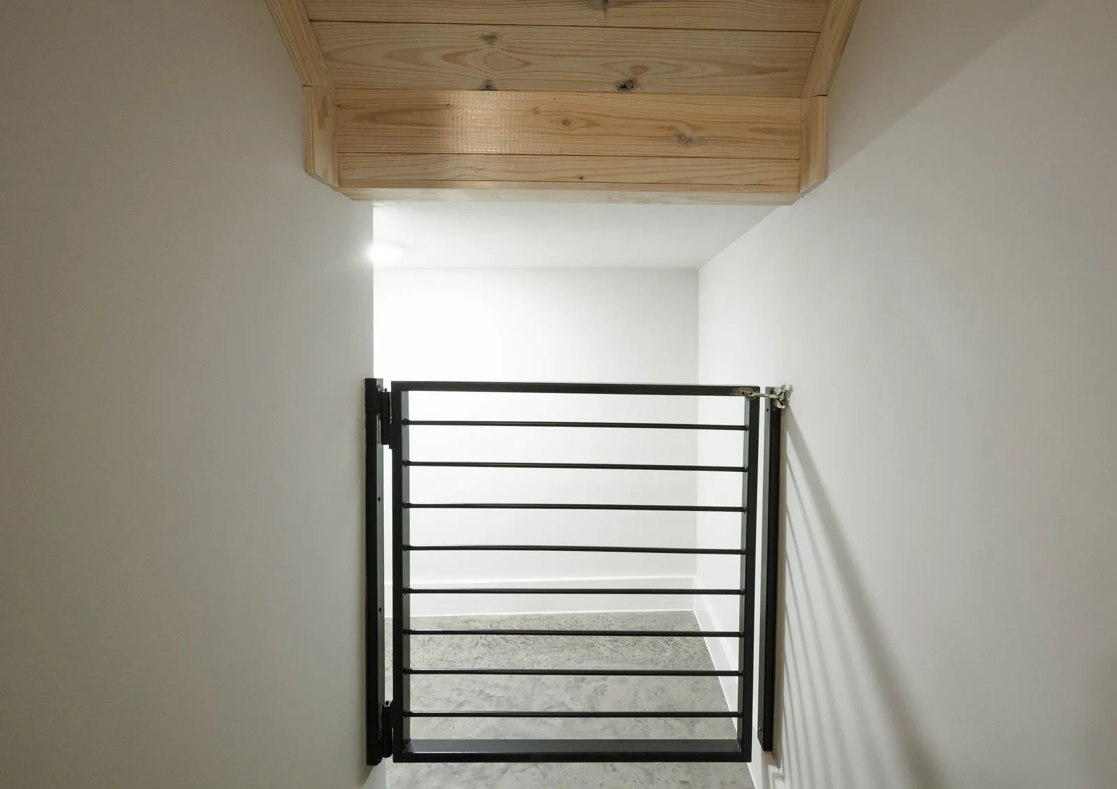 Bedroom at The Aroha with king bed, wood ceiling, pendant light, and sliding glass doors to balcony