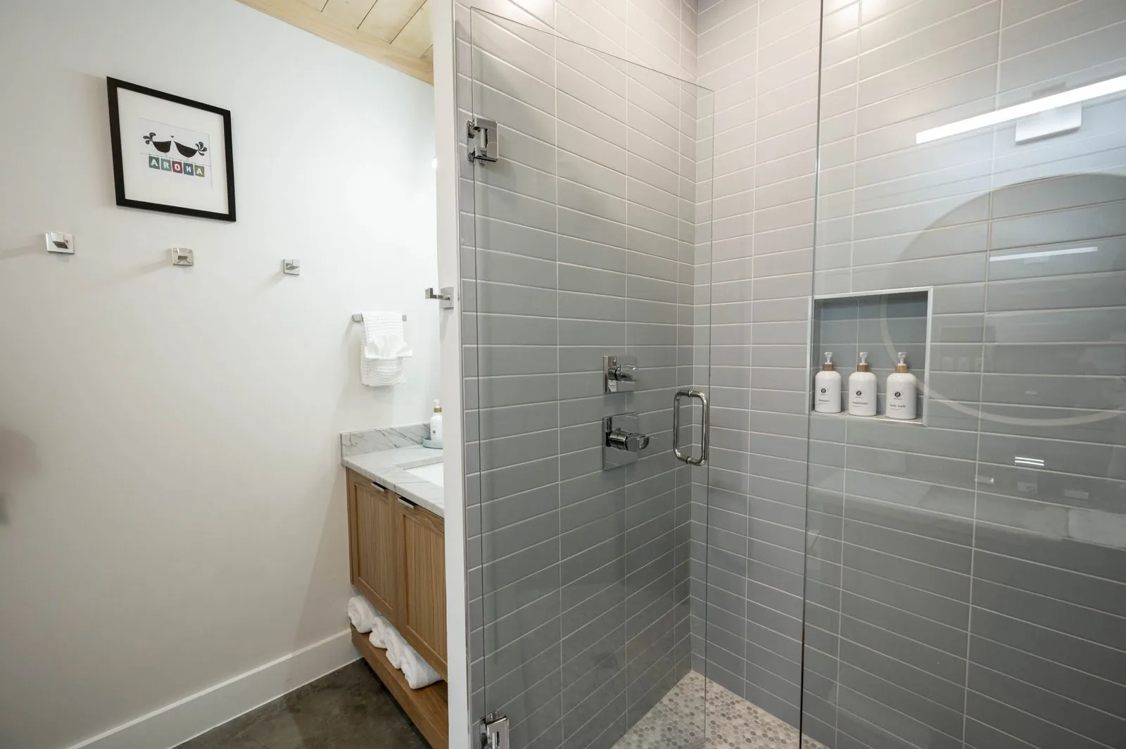 Bedroom sitting area at The Aroha with boucle bench and ensuite bathroom entry