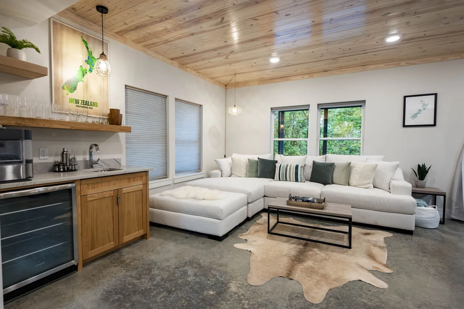 Bunk room at The Aroha with built-in twin bunks, blue accent walls, wood ceiling, and wall-mounted TV