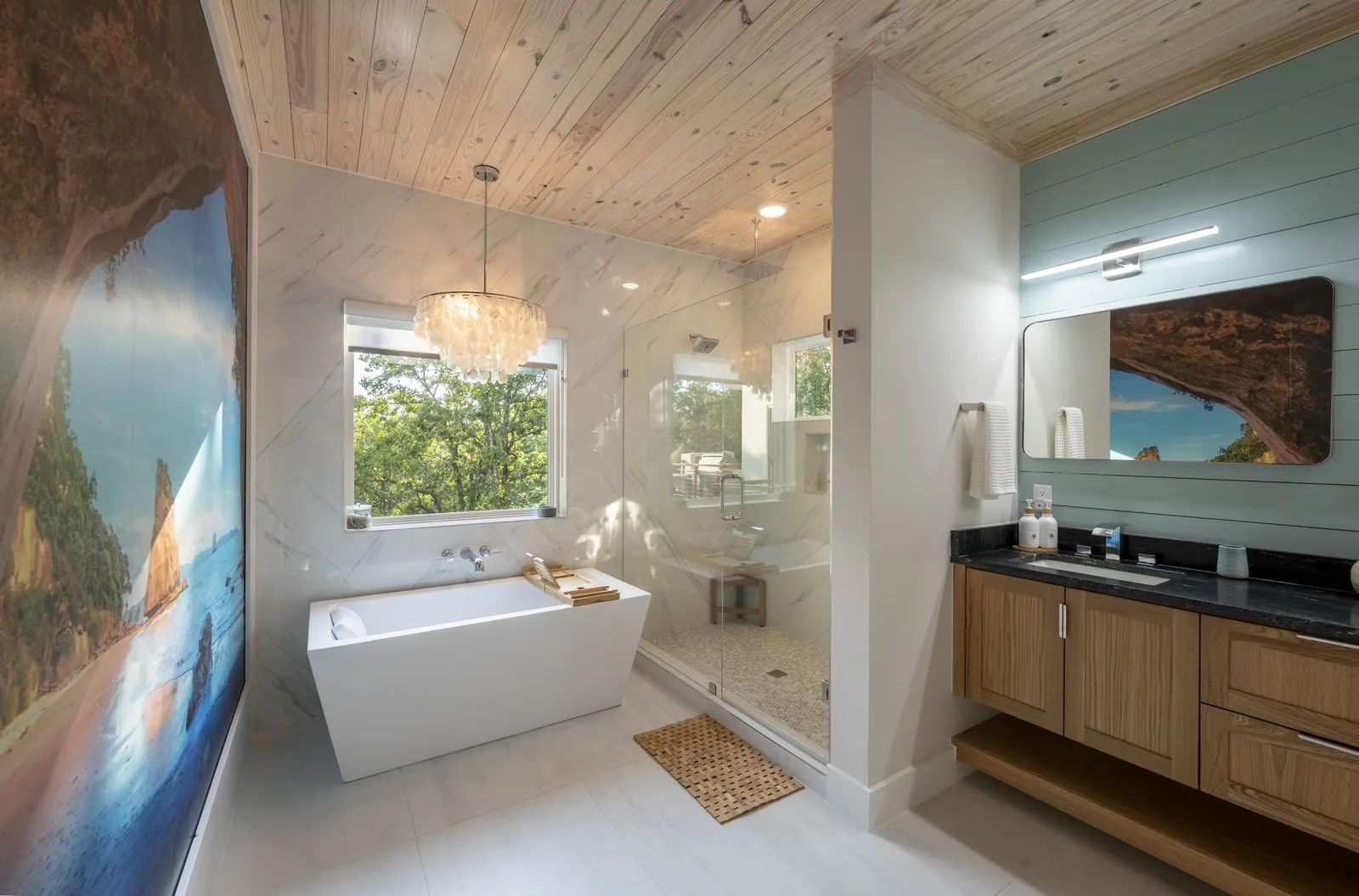 Half bathroom at The Aroha with sage green vanity, framed mirrors, and New Zealand artwork