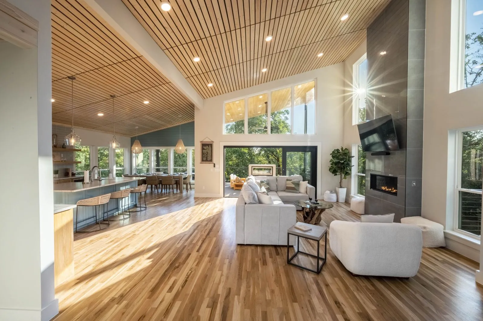 Great room at The Aroha with a fireplace, dining, and open kitchen