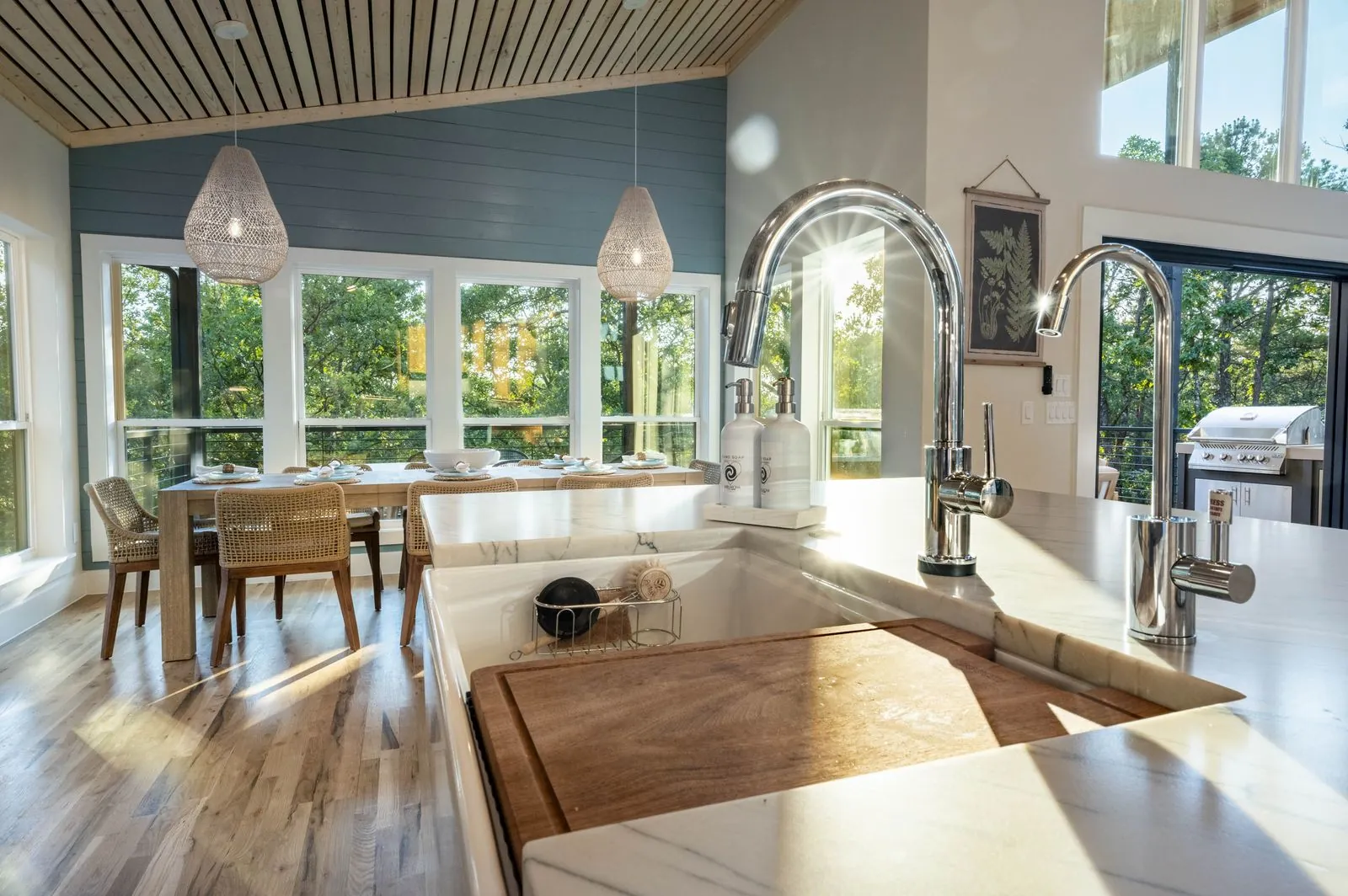 Kitchen at The Aroha with blue island, farmhouse sink, and bar stools from elevated angle