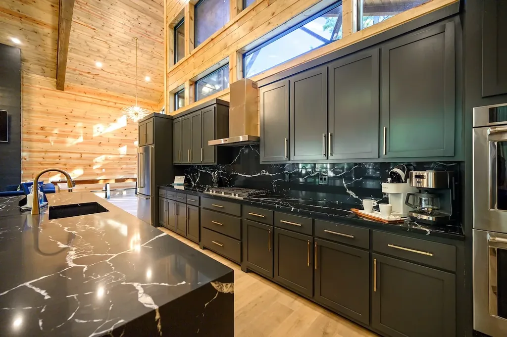 Black marble kitchen counters, cabinetry, and coffee station