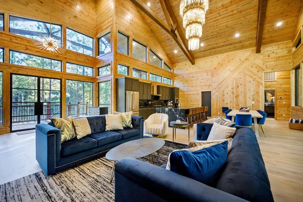 Wide living room with blue sofas, fireplace, and vaulted ceiling