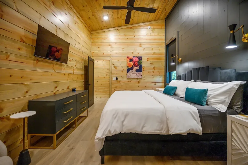 King Bedroom 2 with dark wall, dresser, and colorful artwork
