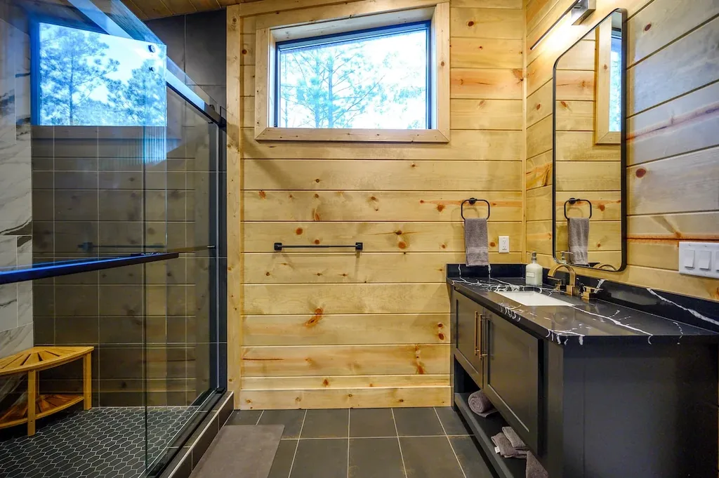 Full Bathroom 1 with glass shower, double vanity, and skylight
