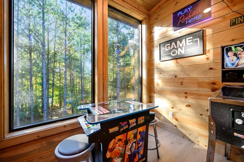 Pinball machine beside the game room's forest-view windows