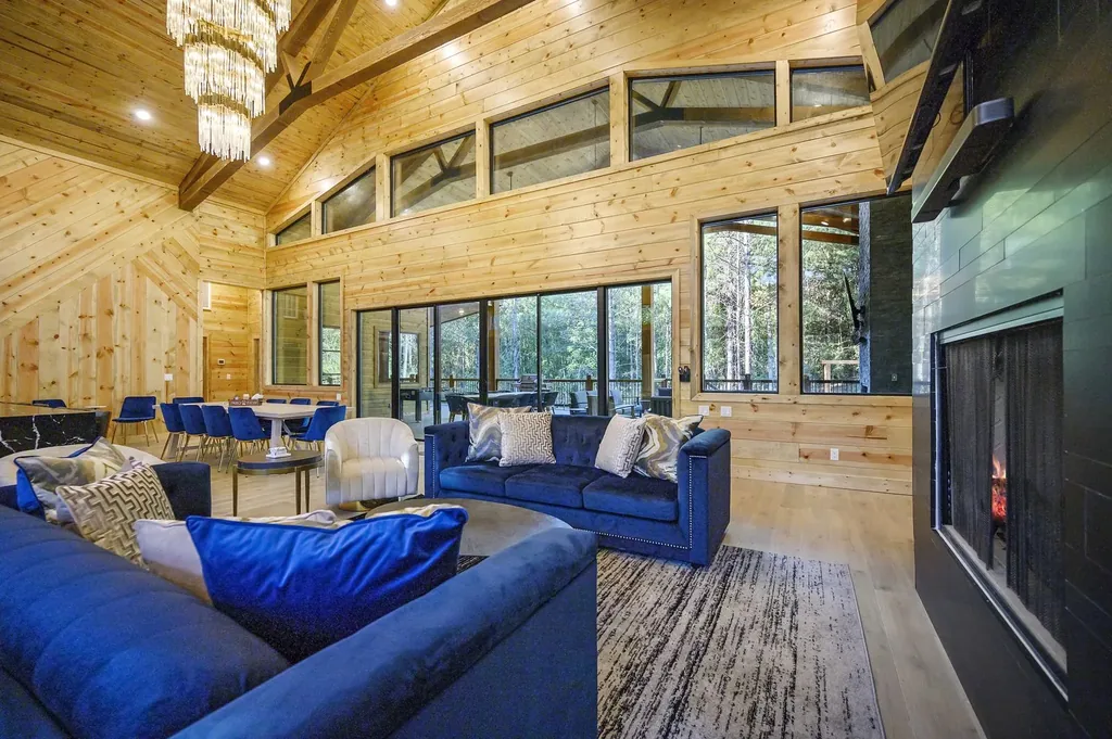 Great room at The Avalon with blue velvet sectionals, crystal chandeliers, vaulted wood ceiling, and floor-to-ceiling windows