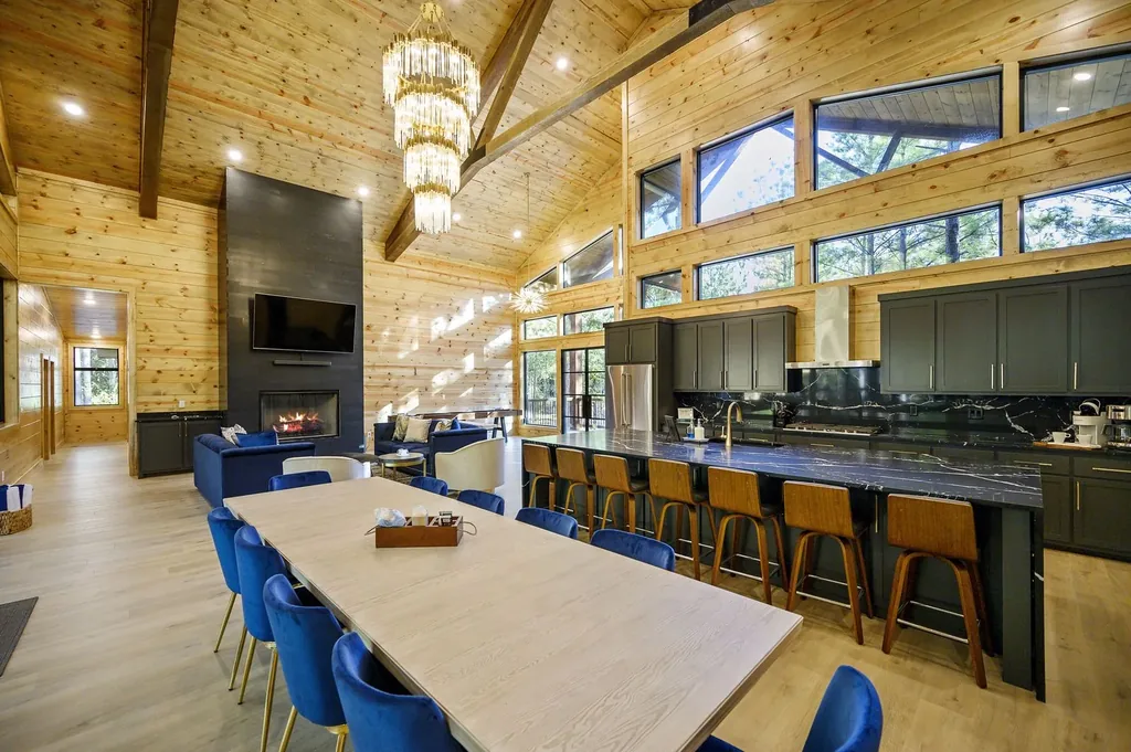 Kitchen sink area at The Avalon with black marble countertop, dark cabinetry, and forest views through window