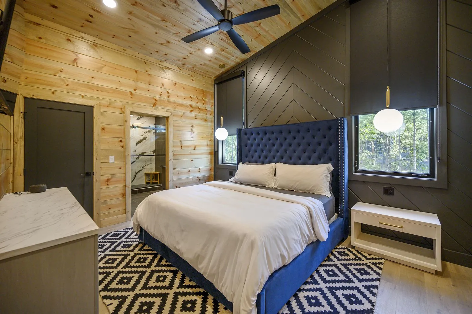 Second bunk room at The Avalon with twin bunks, gray bedding, and warm wood-paneled walls