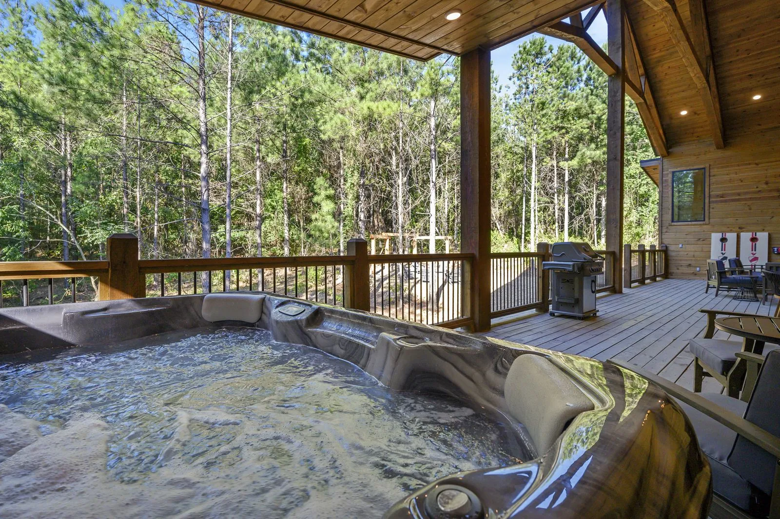 Outdoor hot tub and stainless steel grill on the covered deck at The Avalon