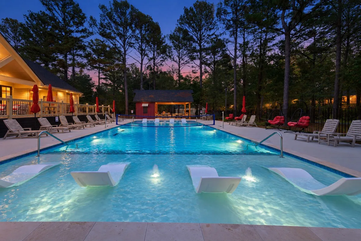 Shared Three Creeks pool with in-water loungers and a volleyball net
