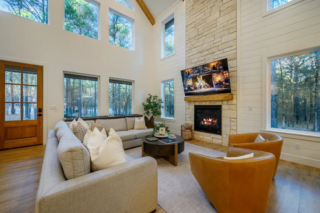 The Black-Beary — Gather around the stone gas fireplace beneath a vaulted, window-lined ceiling that fills the living room with natural light.