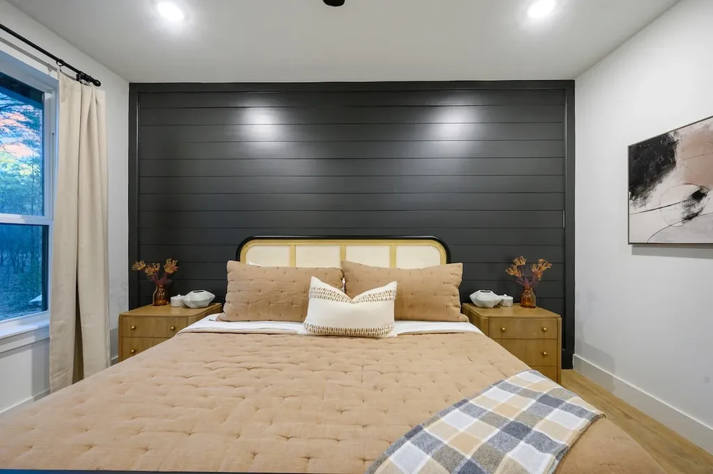 The Black-Beary — Rest easy in a king bed framed by a striking dark shiplap wall and warm wood accents.