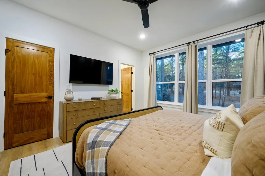 The Black-Beary — Wake up to a wooded view through floor-to-ceiling windows in this bedroom with its own mounted flat-screen TV.