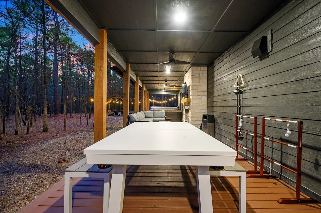 The Black-Beary — Unwind on the covered patio with built-in games and a wooded backdrop just steps from the seating area and hot tub.