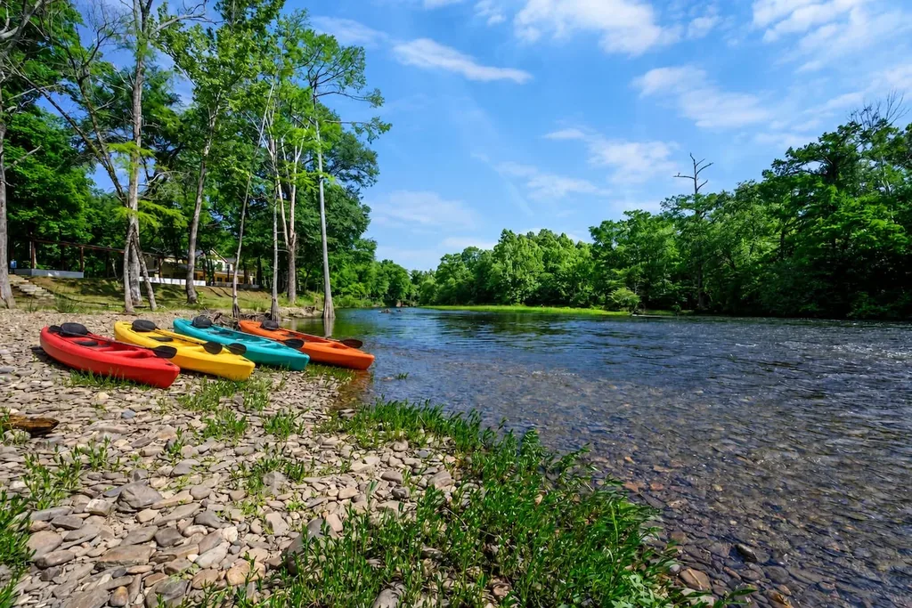 Kayaks on the community beach along the Mountain Fork River near Blue Note