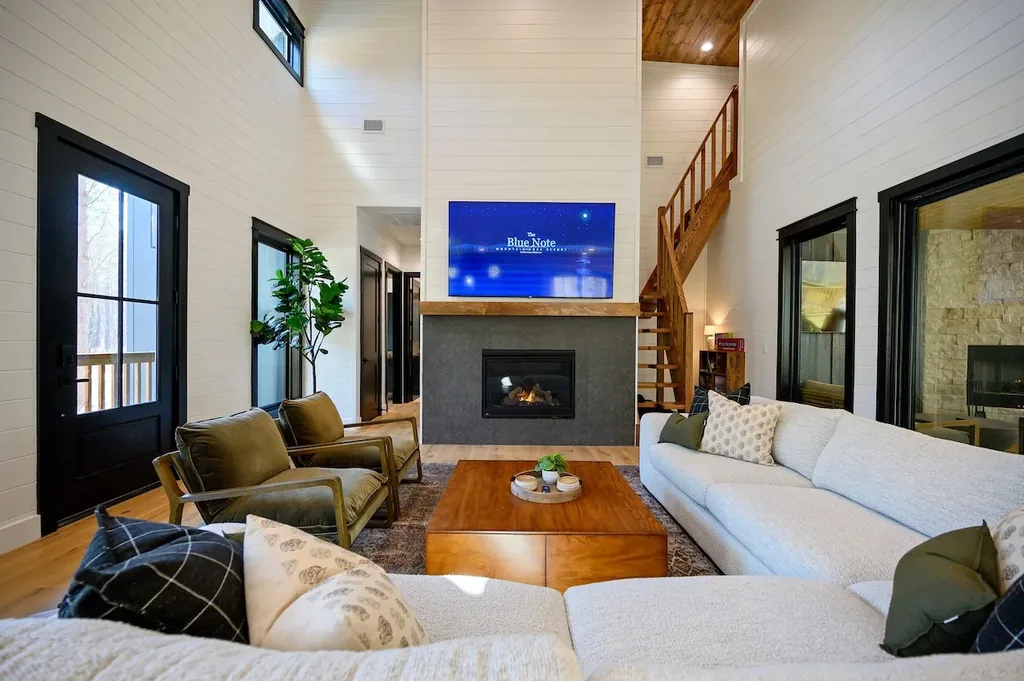 Blue Note living room with fireplace, sectional and forest views