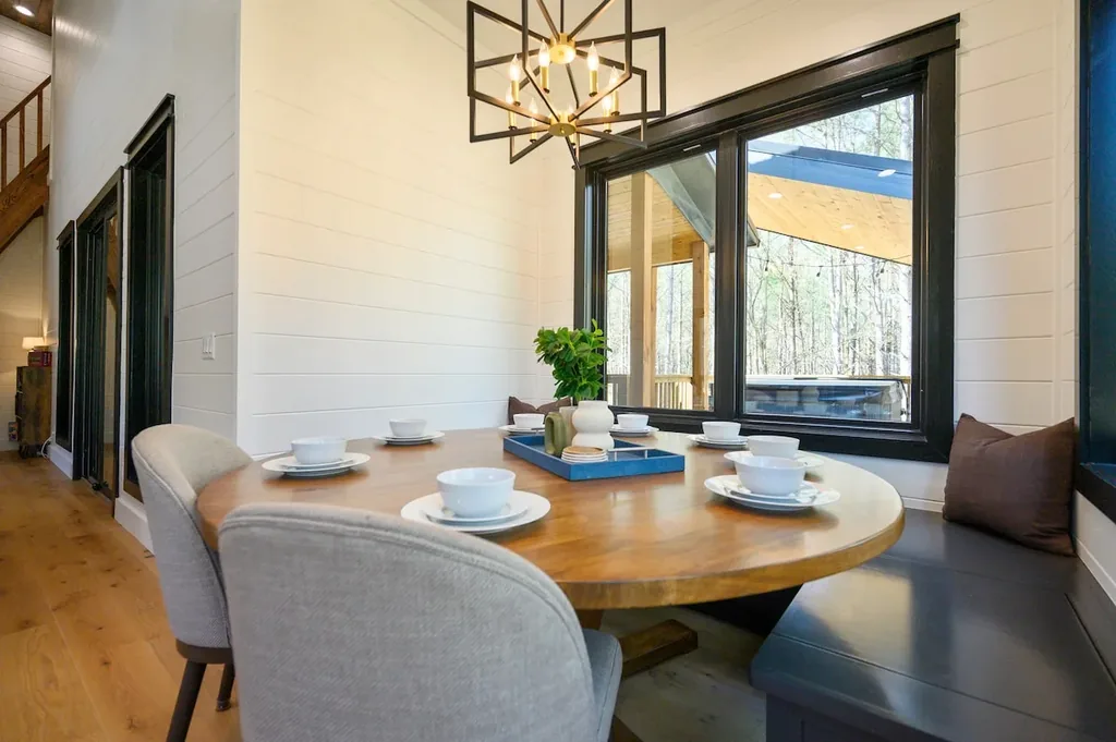 Blue Note dining area with round table and forest views