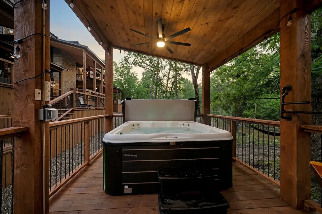 Covered hot tub viewed from the cabin walkway