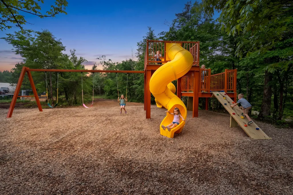Custom playground with rock wall, swings, and slides at Dreams & Streams