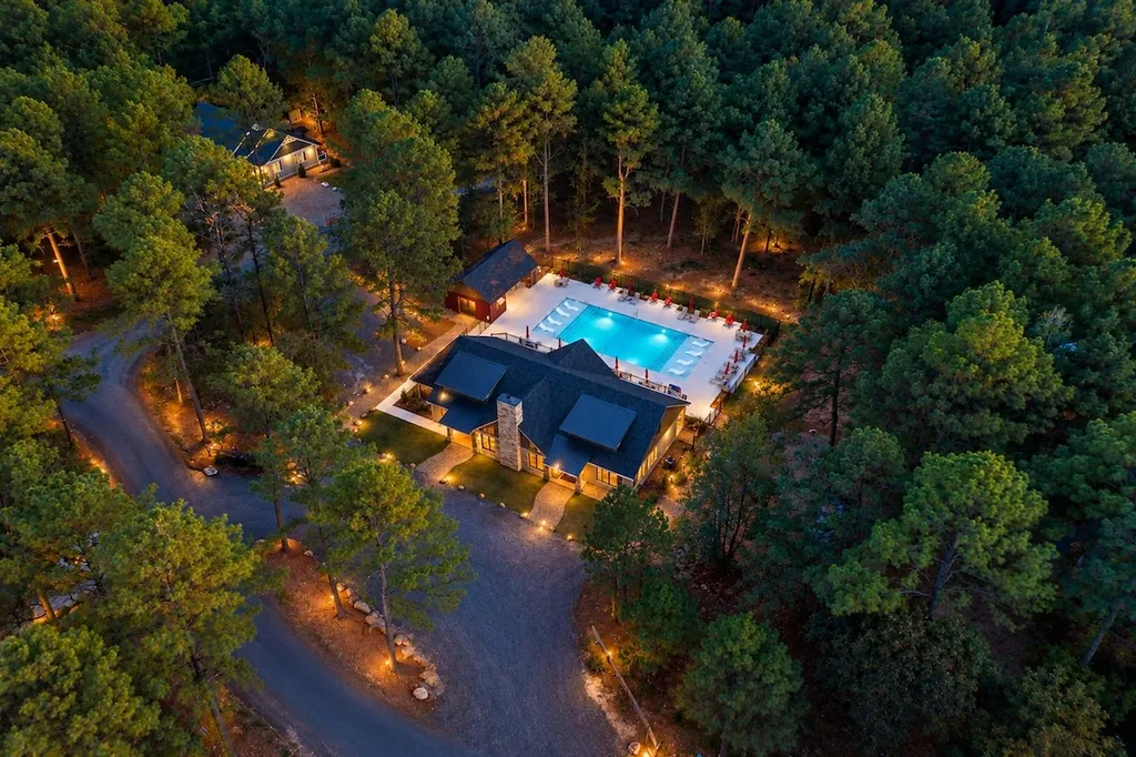 Aerial twilight view of the Three Creeks Reserve clubhouse and resort-style pool, a shared amenity included at no extra cost and within walking distance of the cabin.