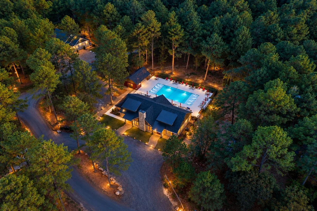 Aerial twilight view of the Three Creeks Reserve clubhouse and resort-style pool, a shared amenity included at no extra cost and within walking distance of the cabin.