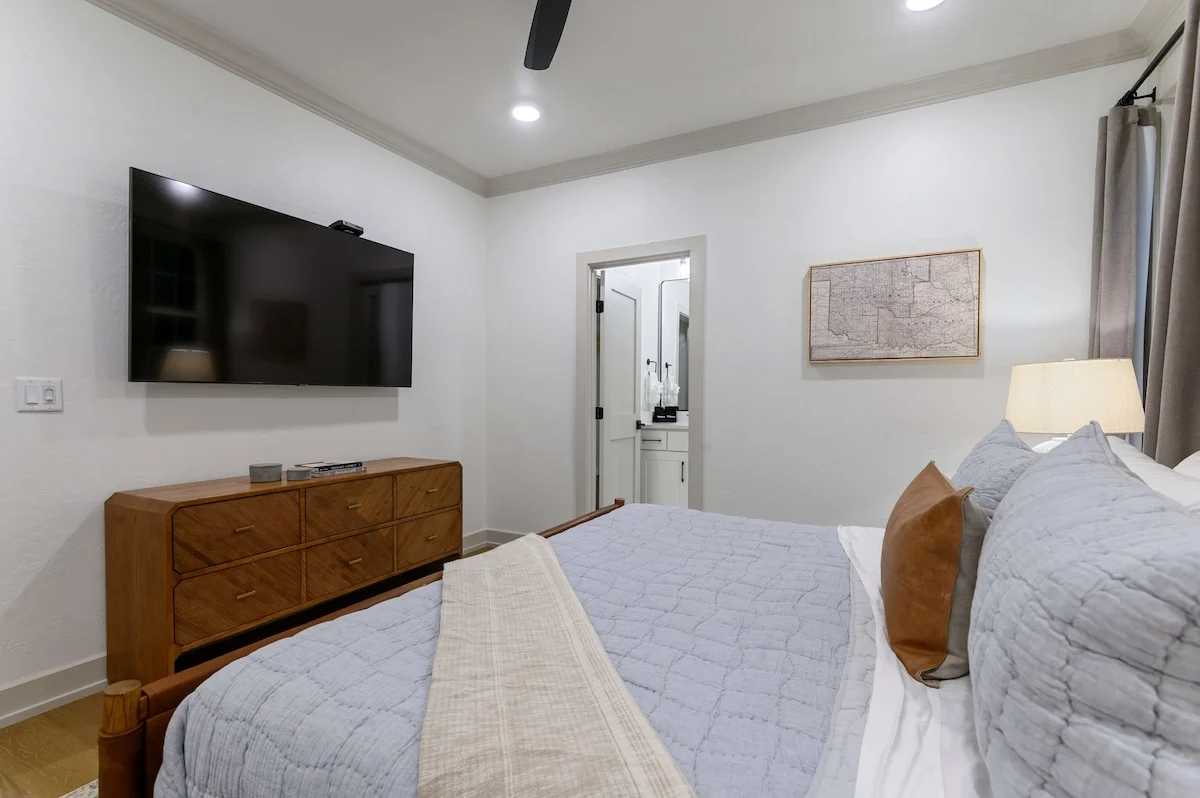 One of three king suites, this bedroom has a king bed, a wall-mounted smart TV, and its own private ensuite bathroom.