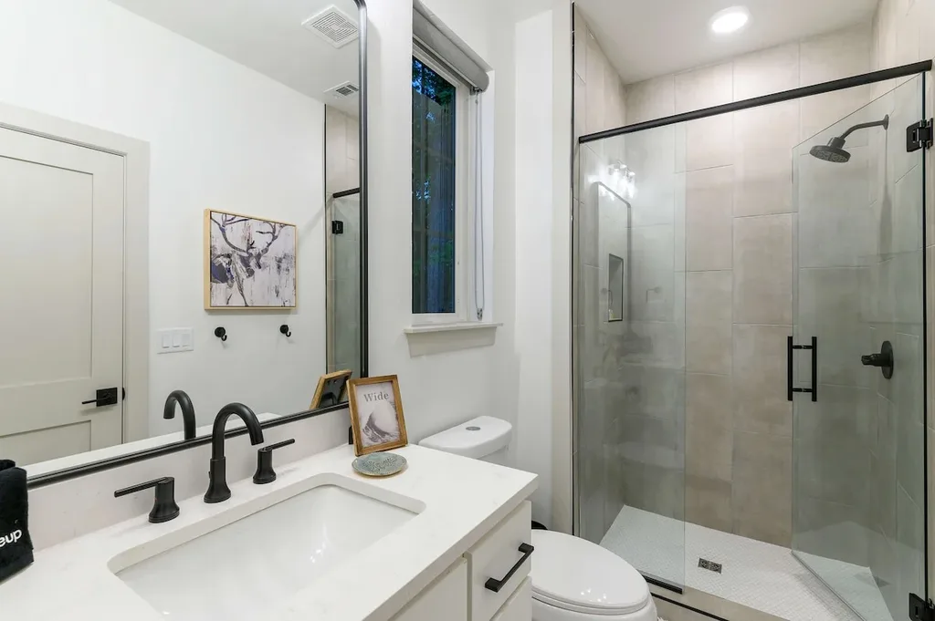 Wake up to a private ensuite with a spacious glass walk-in shower and clean, modern finishes.