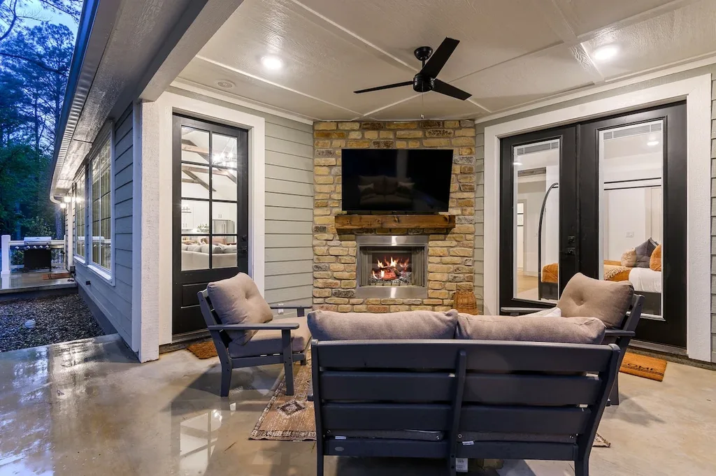 Unwind by the private stone fireplace on the covered back patio, complete with a mounted TV and comfortable lounge seating.