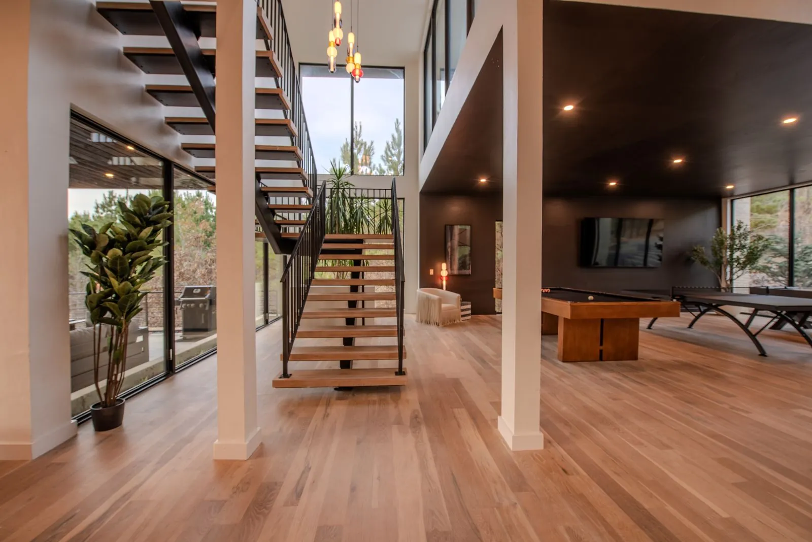 Multi-level interior of The Jade showcasing pool table, spiral staircase, and connected living spaces across two floors