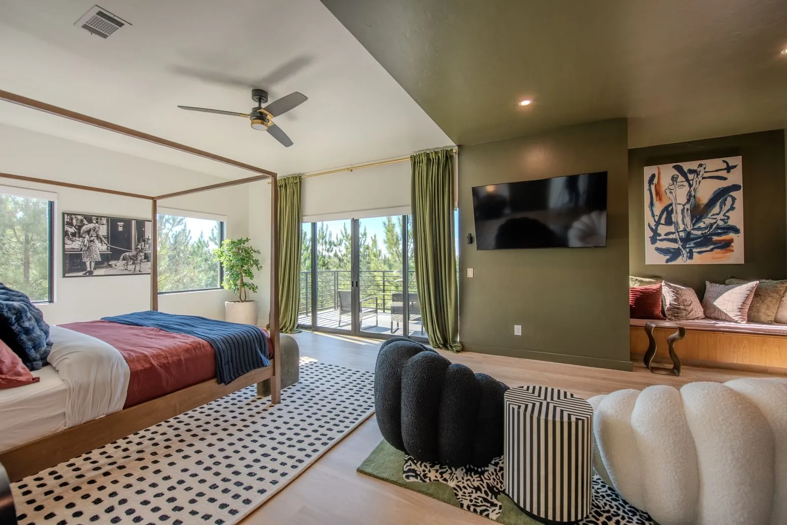 Dining room at The Jade with ceiling fan, modern artwork, and oversized windows showcasing the surrounding nature