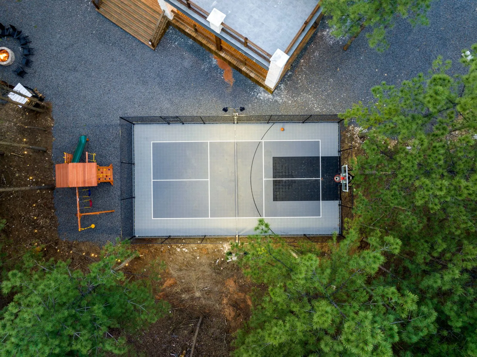 Aerial drone view of the private pickleball court at LivNLove surrounded by lush forest canopy