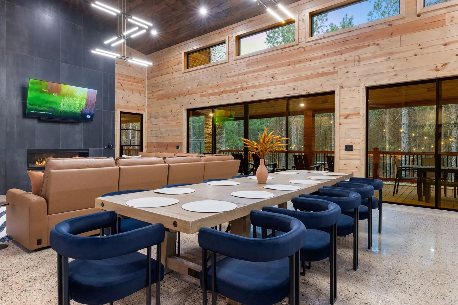 Kitchen island with tan leather bar stools, dark blue cabinetry, and globe pendant lights at LivNLove