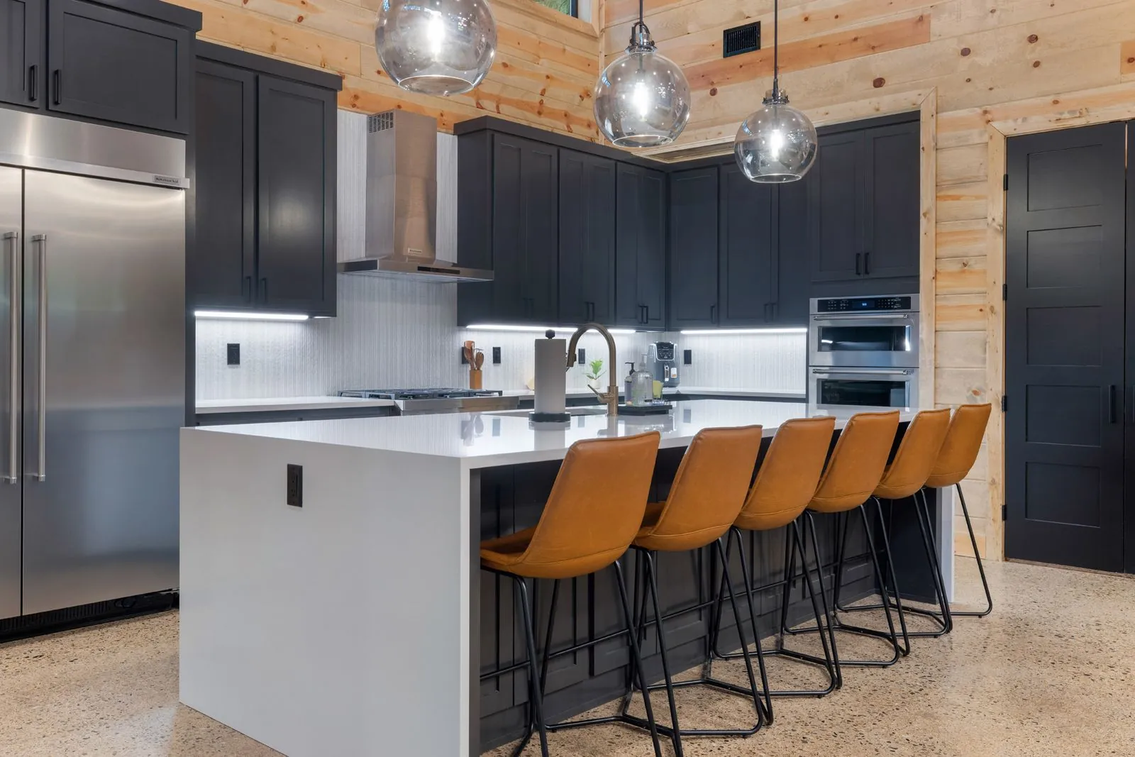 Coffee and beverage station at LivNLove with wine glass rack, espresso machine, and white countertops