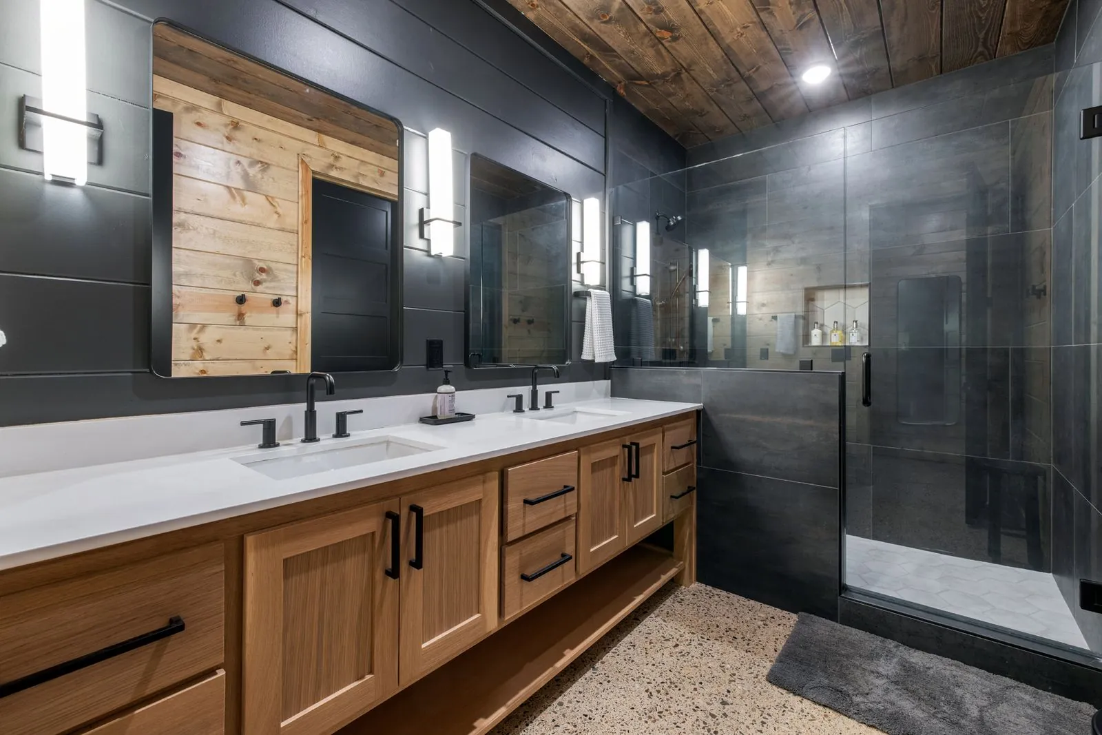 Walk-in rainfall shower at LivNLove with dark gray tile, rain showerhead, and matte black fixtures