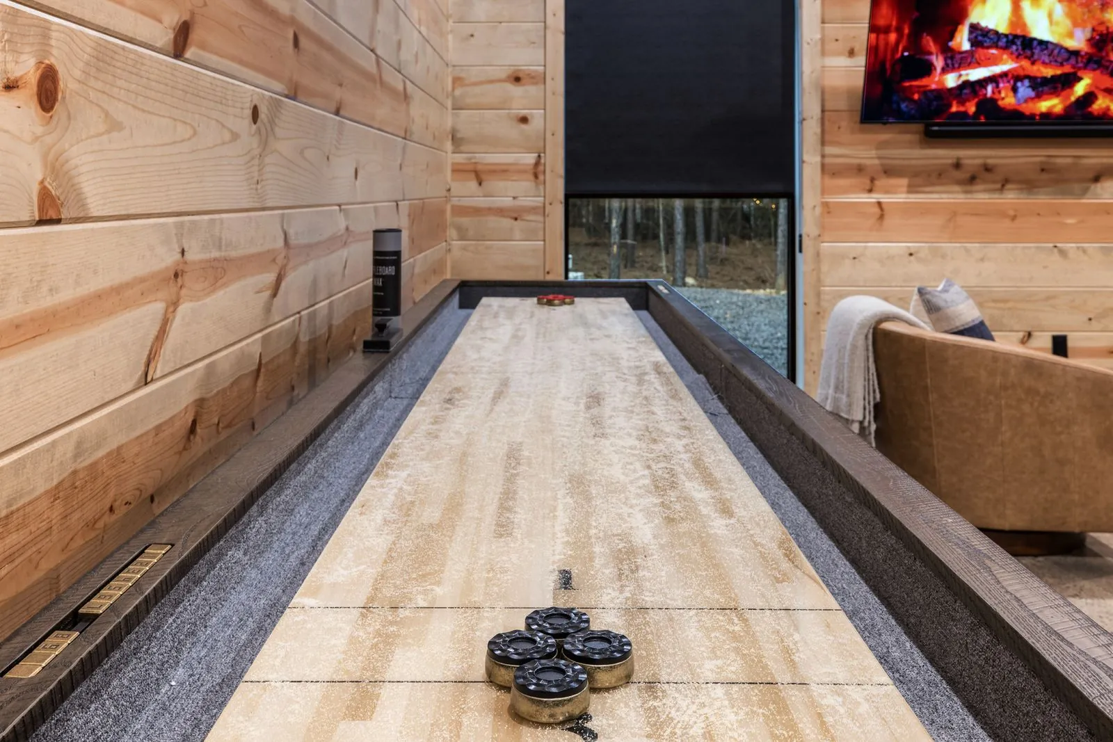 Private bowling alley lane inside LivNLove cabin with warm wood paneling and ambient lighting