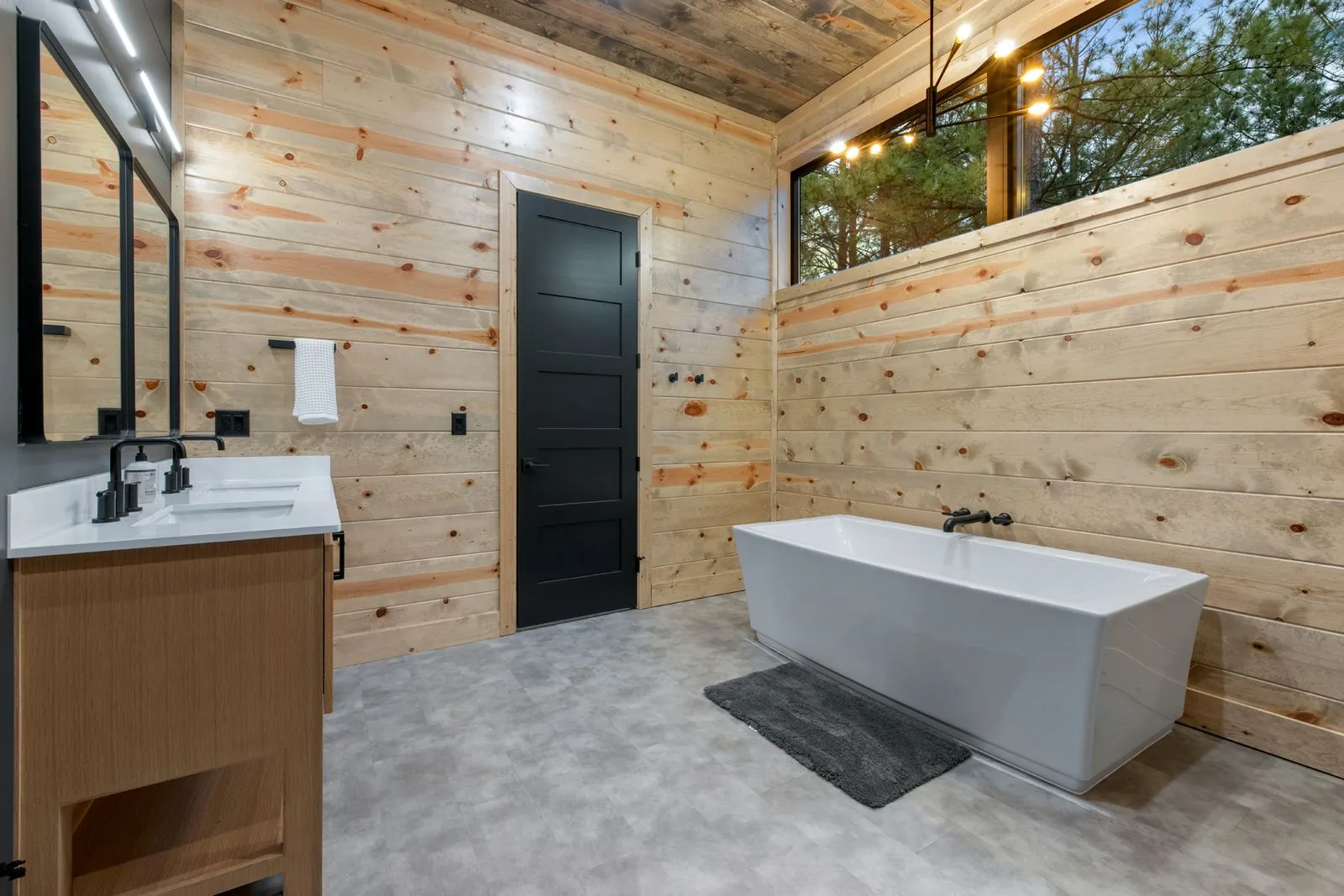 Spa-style walk-in shower at LivNLove with dark tile walls, dual shower heads, and glass enclosure