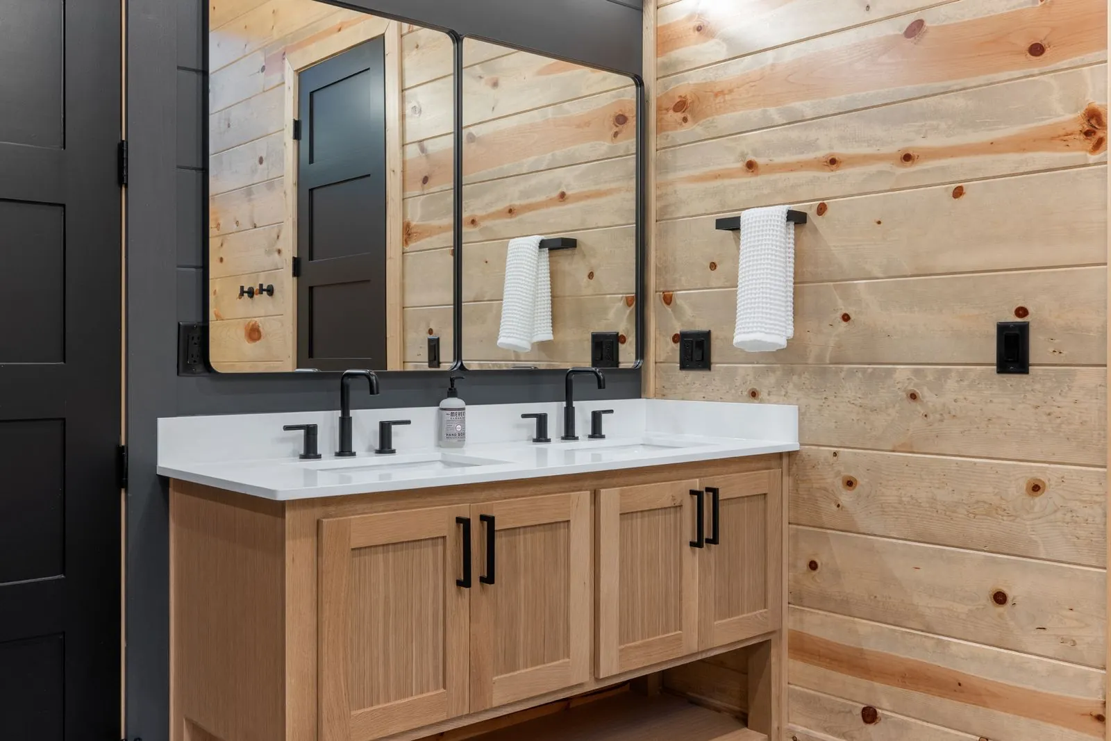 Walk-in glass shower with dark tile walls, integrated bench seating, and rain showerhead at LivNLove